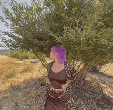 a woman (Angelina Young) with purple hair and a leopard print dress