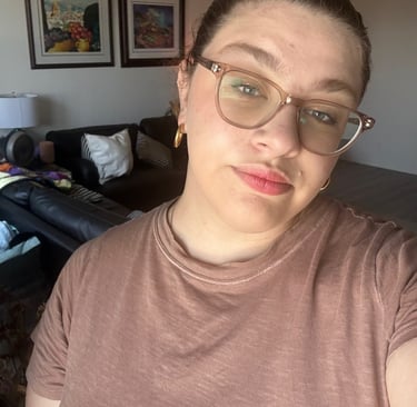 a woman with glasses and a brown shirt