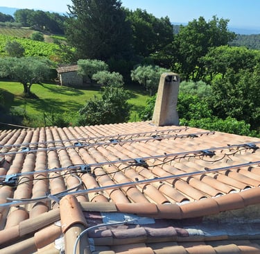 Rails, micro-onduleurs et mise à la terre installés sur la toiture à Pierrevert, avec vue sur les vignes et la forêt des Alpe
