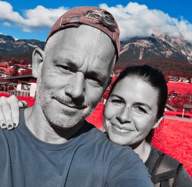 a man and woman taking a selfie in a red - hued photo