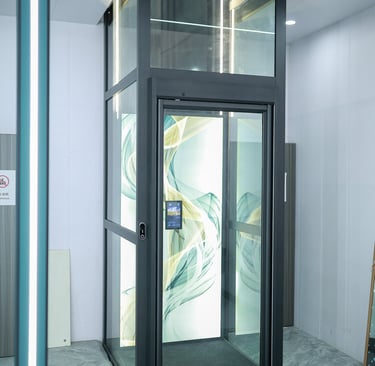 Modern luxury glass residential elevator with a custom artistic back panel installed in a home.