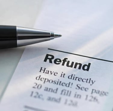 A close-up of a pen pointing to a tax refund direct deposit section on a paper document.