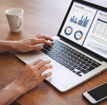 Professional analyzing financial report and sales performance data charts on a laptop screen.