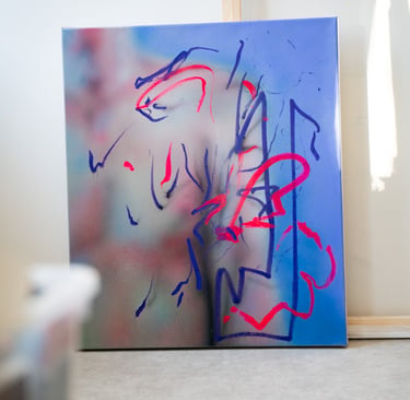Contemporary abstract canvas art with blue spray paint and neon red gestural lines on an easel.
