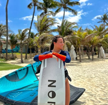 mulher com prancha de kitesurf na praia.