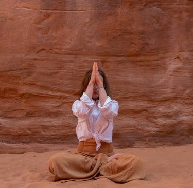 a woman in a white shirt and pants is doing yoga