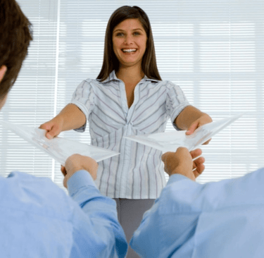 Jovem líder sorrindo enquanto delega trabalho para a equipe