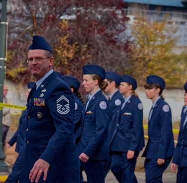a group of people in uniform uniforms walking down a street