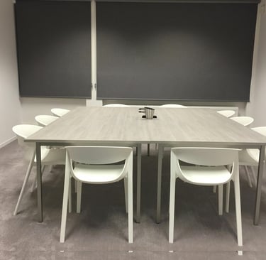 Lege lerarenkamer met tafel en stoelen. Stil beeld dat het gemis aan ontmoeting en leven symboliseer