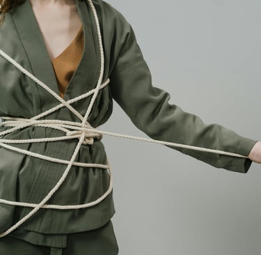 Persoon verstrengeld in touw, symbool voor het dilemma tussen regels en menselijkheid.