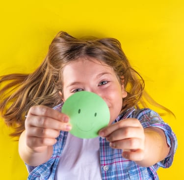 a young girl with a green smiley face