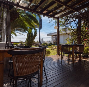  Área externa coberta do Kaizen com bar e mesas em madeira