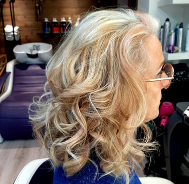 Une femme aux cheveux blonds avec des lunettes sur la tête.