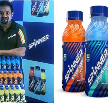 Muthaih Murlidharan holding a bottle of energy drink spinner