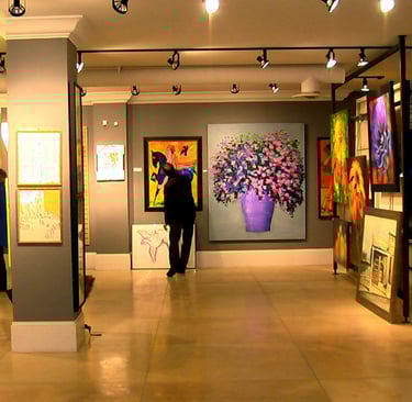 a person standing in a room with paintings on the walls in Mount Royal Calgary