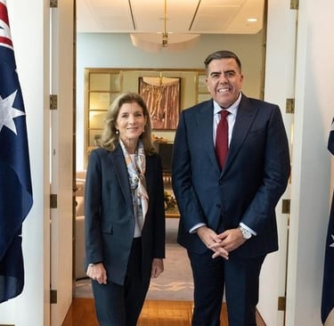 Two people standing with Australian flags beside them