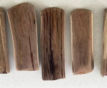 5 hardwood coolamons on a table