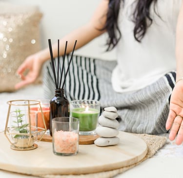 a woman sitting on a bed with candles and practice yoga part of herbal wellness