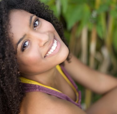 a woman with curly hair and a yellow top