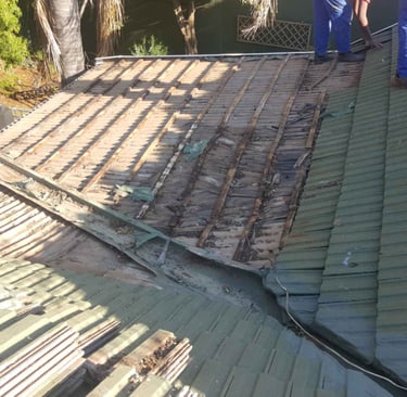 Non-compliant roof showing exposed battens and deteriorated waterproofing.