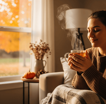 a woman sitting on a couch with a cup of tea