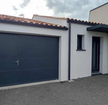 porte de garage noire avec porte intégrée et porte d'entrée en pvc posée par l'artisan menuisier