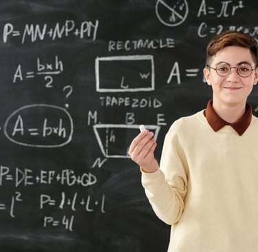 a boy in a white sweater and glasses standing in front of a blackboard