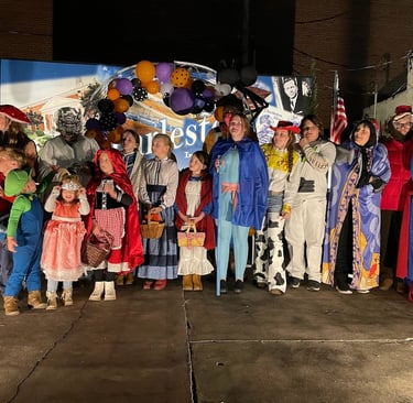 Charleston Halloween Costume Contests participants in front of the sign in Main Street Park.