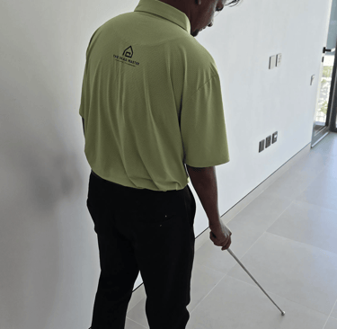 Snagging engineer inspecting hollow tiles using tile hammer rod in Dubai apartment