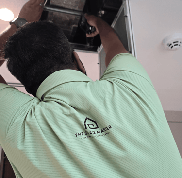 Snagging engineer inspecting false ceiling duct with flashlight in Dubai villa