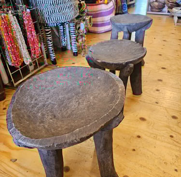 a three old wooden stools in a store