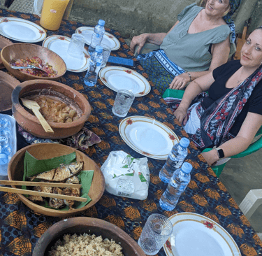 a group of people sitting around a table with plates of food