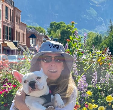 a woman in a hat holding a dog
