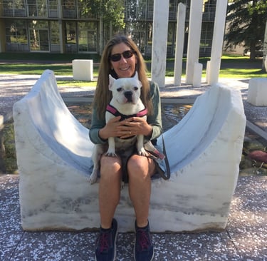 a woman sitting on a bench with a dog