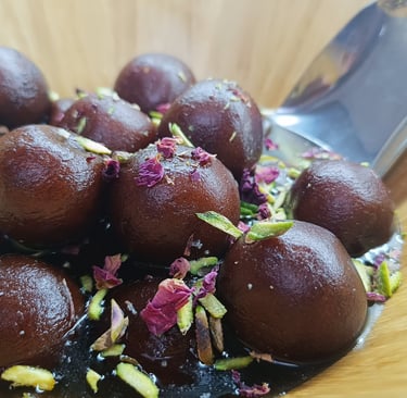 Mawa Gulab Jamun with rose petals and crushed pistachios – a gourmet twist on a classic dessert,