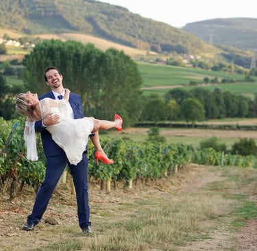 Photography of a vineyard landscape in burgundy france with the groom holding the bride in his arms.