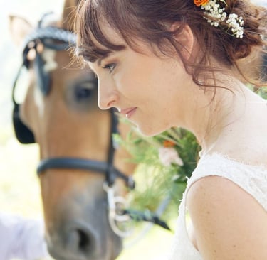 Portrait de mariée avec des fleurs dans les cheveux devant un cheval