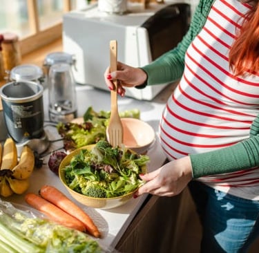 mulher gravida preparando comida saudavel