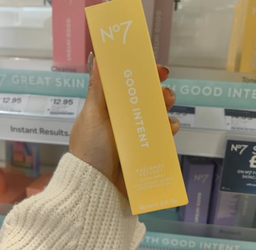 White text on the yellow packaging of Radiance Reflect Serum Spray packaging for Boots No7 Good Intent skincare range