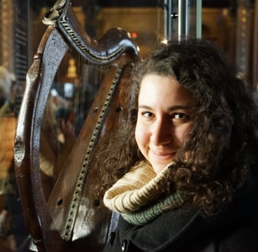 Federica smiling with a Irish harp in the background