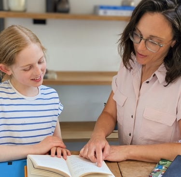 A Kent tutor and primary school girl reading a book together during an 11+ tutoring session