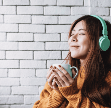 Mulher sorrindo segurando uma xícara de café especial, representando a experiência de tomar o melhor