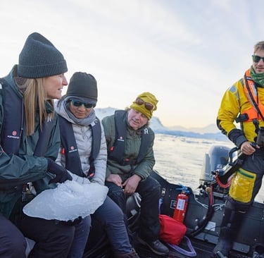 A group of explorers on boat tour, holding a piece of ice, showcasing sustainable polar travel and ecotourism.