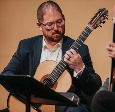 Dan Kyzer plays classical guitar in a performance in Dallas, Texas.
