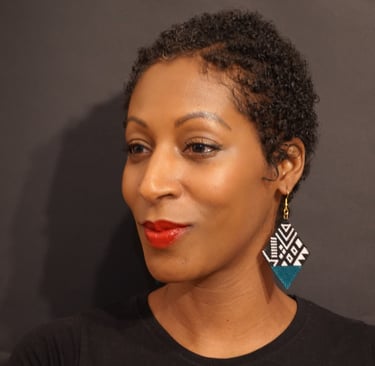 a woman with a black shirt and earrings