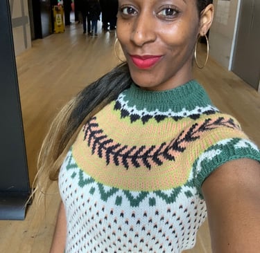 A woman in a knitted sweater with fair isle pattern stitch. She is Tate Modern museum in London