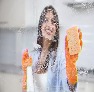 a woman in a blue shirt and orange gloves holding a sponge pad