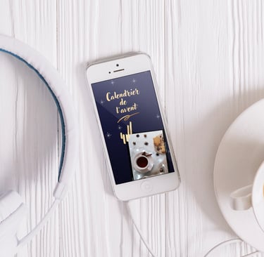 Un téléphone portable est posé sur une table blanche, on y voit un calendrier de l'avent virtuel
