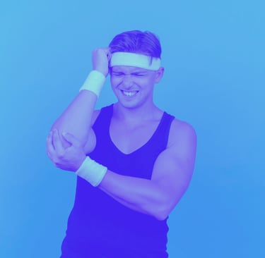 A young man in tennis gear holding his elbow in pain.