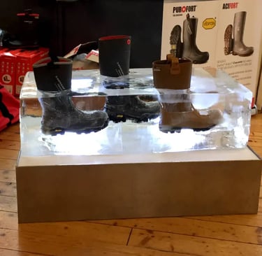 Insulated Dunlop Purofort waterproof work boots frozen inside a large block of ice for a thermal display.